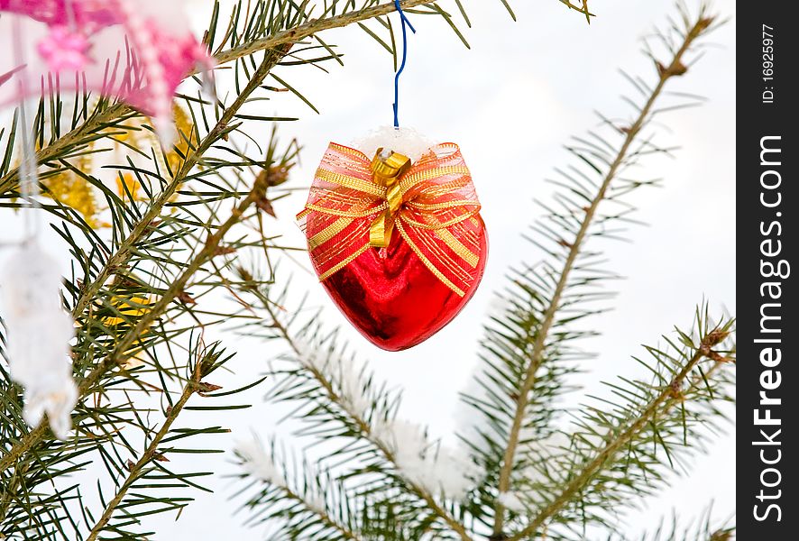 Christmas-tree decoration (red heart) on the tree outdoor