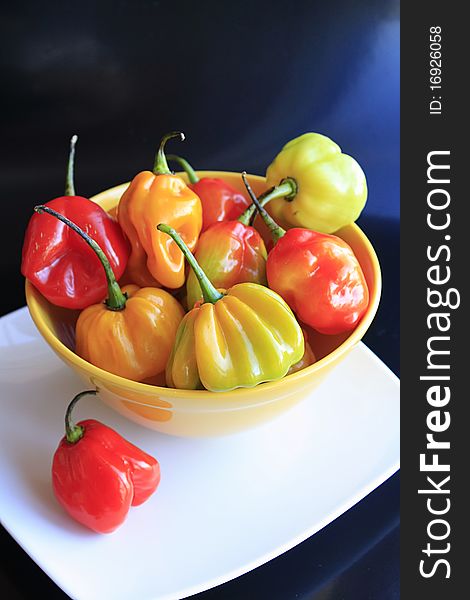 Habanero peppers in a yellow bowl on a white dish