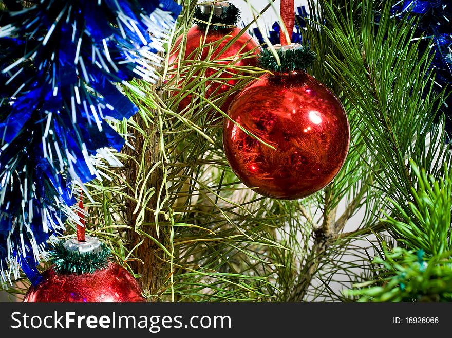 Two red glass balls and tinsel on Christmas-tree. Two red glass balls and tinsel on Christmas-tree