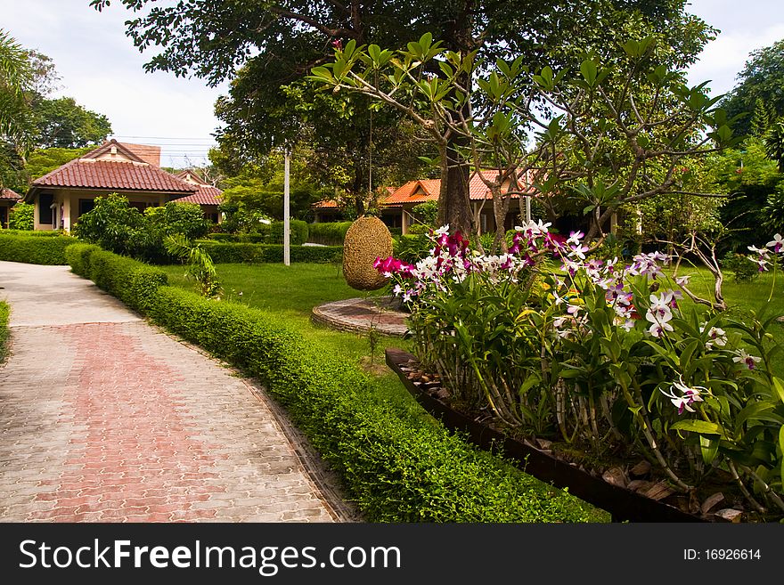 Front of resort on the beach in Thailand with orchid in foreground. Front of resort on the beach in Thailand with orchid in foreground