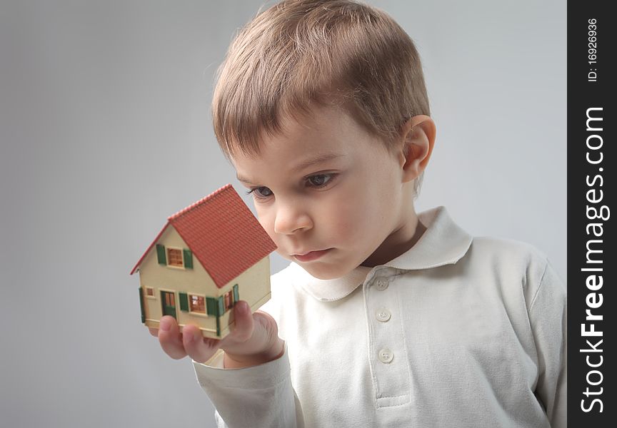 Child holding the model of a house. Child holding the model of a house