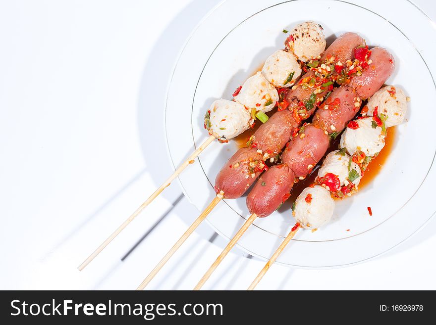 Pour sauce meatball skewers grill plate on a white background. Pour sauce meatball skewers grill plate on a white background.