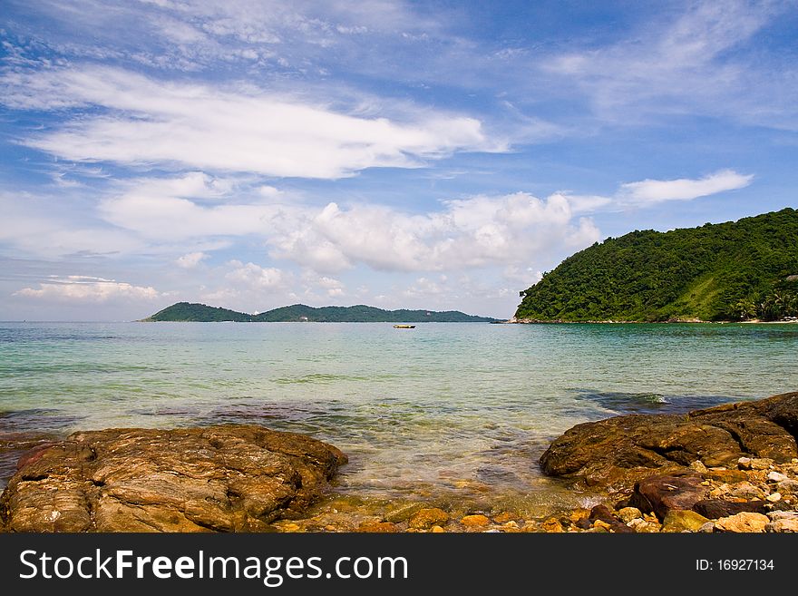 Sea with rock in foreground and island on far. Sea with rock in foreground and island on far