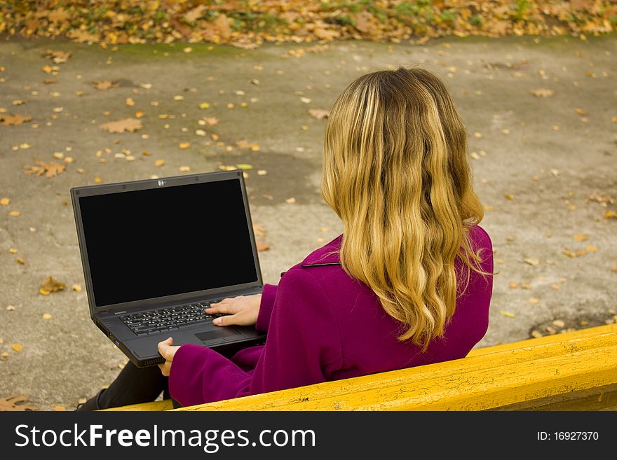 Girl on a bench with a laptop. Girl on a bench with a laptop