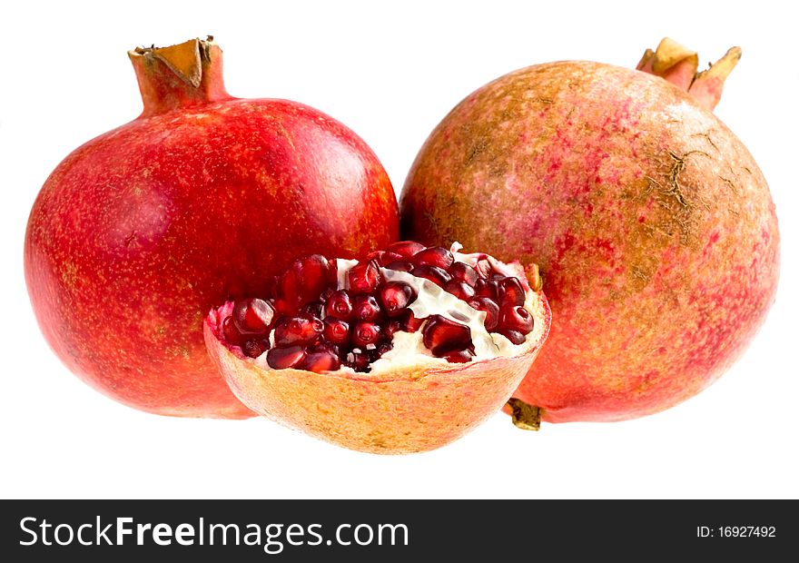 Two whole  and half of broken pomegranates isolated on white