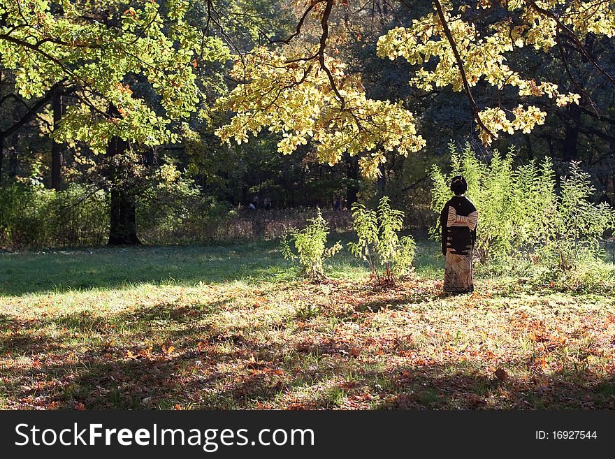 A japanese lady and green and yellow oaks in a forest. A japanese lady and green and yellow oaks in a forest