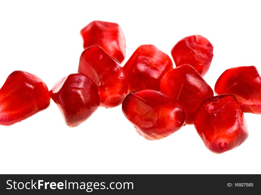 Grains of  pomegranate close-up isolated on white. Grains of  pomegranate close-up isolated on white