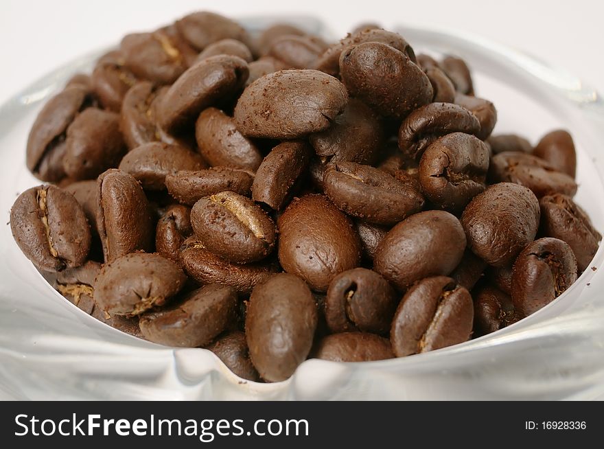 Coffee beans close-up over the glass dish