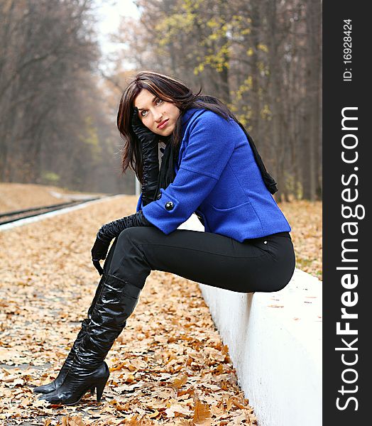 Young woman sitting in the autumn park. Young woman sitting in the autumn park