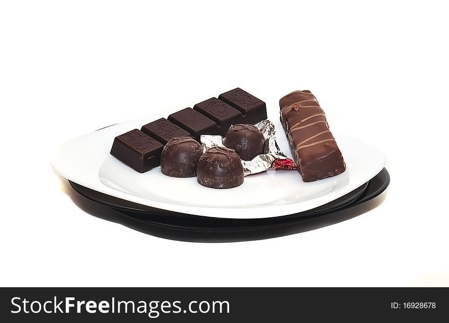 Various chocolate on a plate on a white background