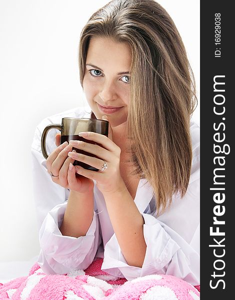 Young attractive girl with cup of tea in bed. Young attractive girl with cup of tea in bed