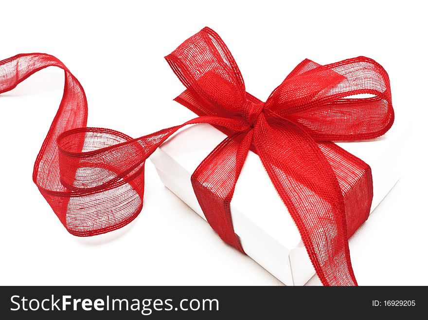 The white gift box with the red ribbon on the white background