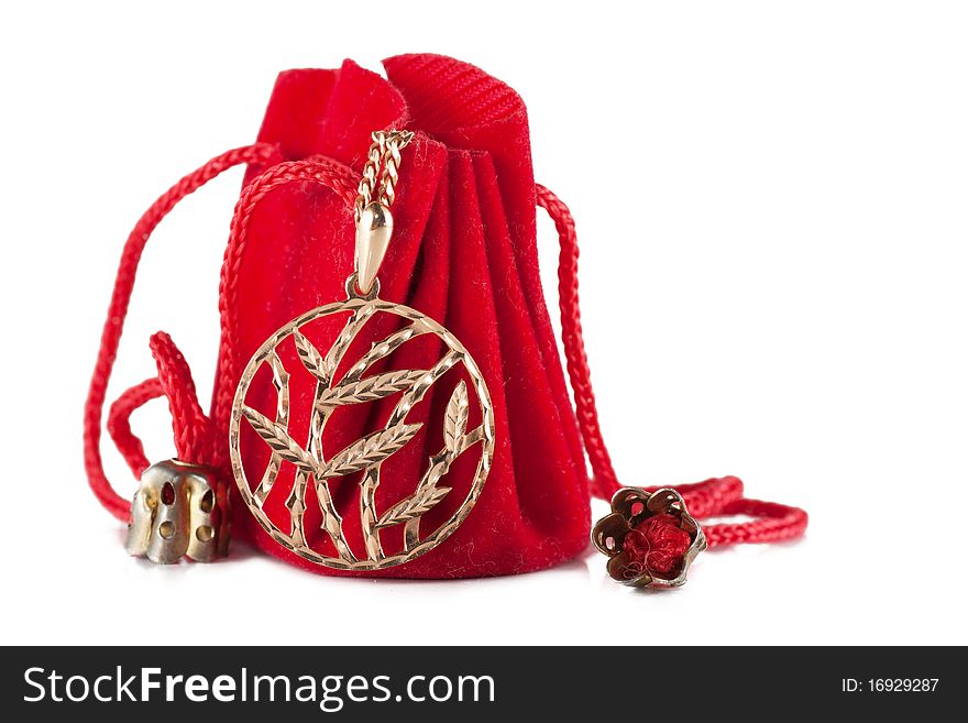 A little red bag with golden pendant isolated over white