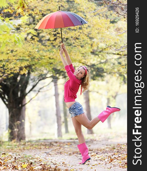 Young happy girl with colorful umbrella on natural background