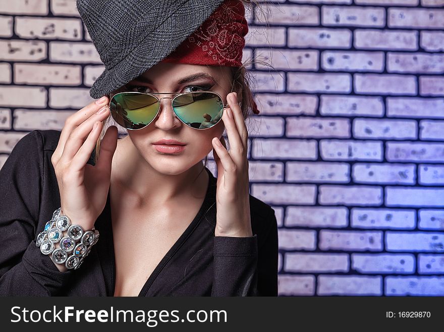 Trendy girl teenager posing  against a brick wall.