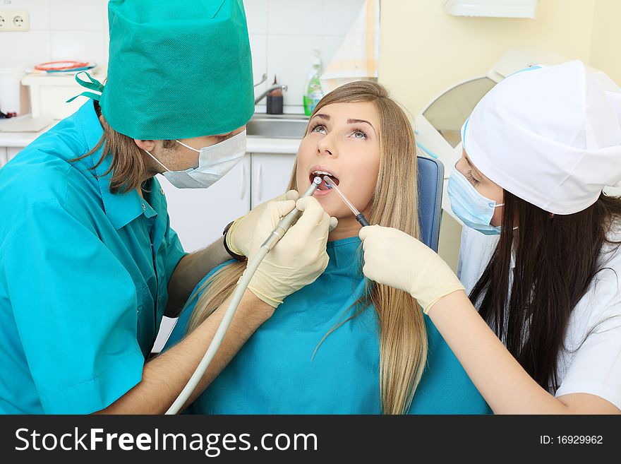 Shot of a young woman with dentists in a dental surgery. Healthcare, medicine. Shot of a young woman with dentists in a dental surgery. Healthcare, medicine.