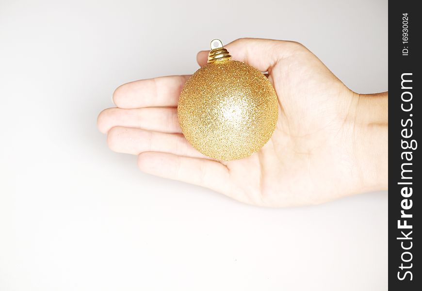 Gold Christmas balls offered in the hands