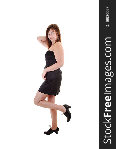 An middle aged woman in an short black dress 
standing for a portrait shot in the studio, for white background. An middle aged woman in an short black dress 
standing for a portrait shot in the studio, for white background.