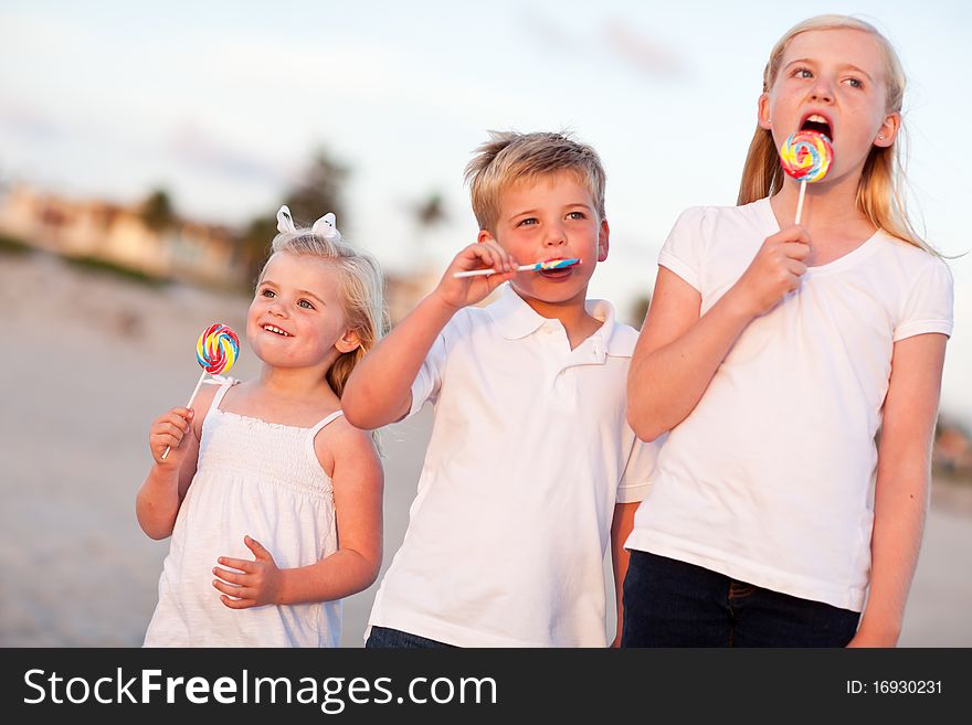 Brother and Sisters Enjoying Lollipops Outside