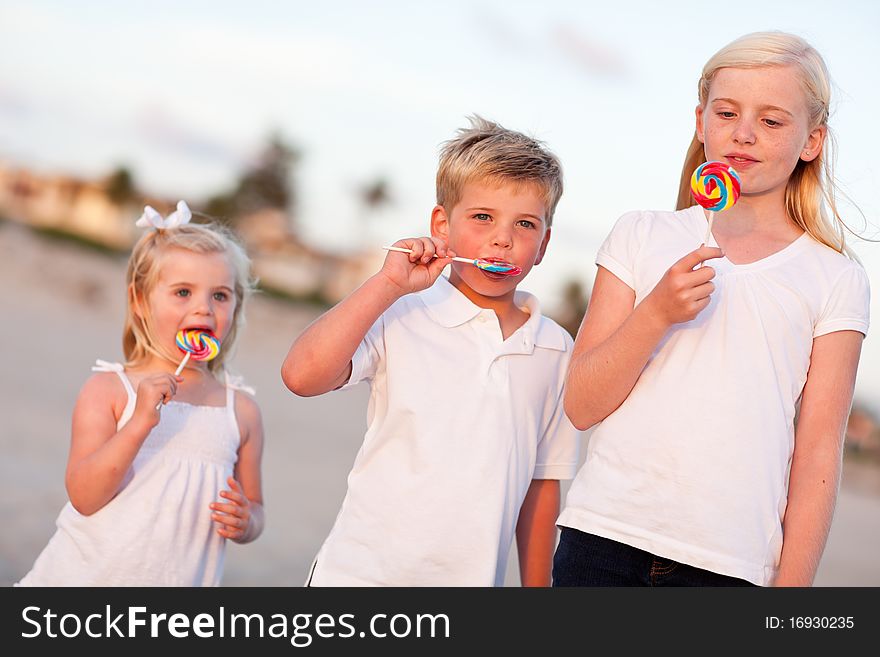 Cute Brother and Sisters Enjoying Their Lollipops