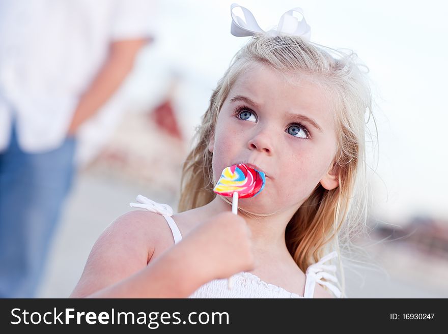 Adorable Little Girl Enjoying Her Lollipop Outside at the Beach.