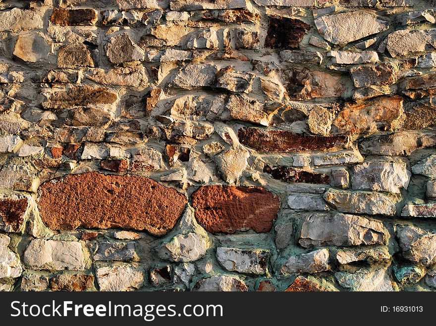 Traditional stone brick wall made of fragment stones in irregular shapes. Traditional stone brick wall made of fragment stones in irregular shapes.