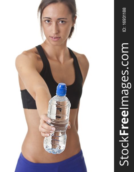 Sports Woman offering a water bottle shalow focous on the bottle. Sports Woman offering a water bottle shalow focous on the bottle