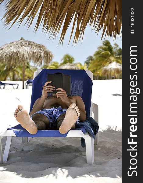 Man on the beach reads a book