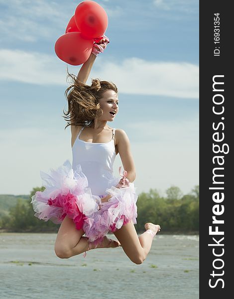 Young Beautiful Woman Jumping With Balloons.