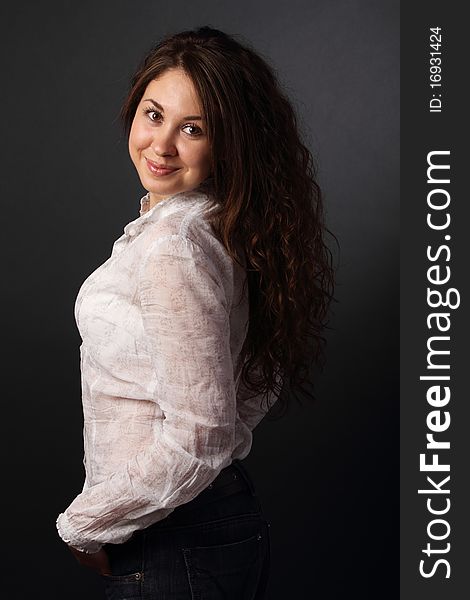 Portrait of the smiling girl over dark background