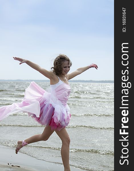 Young woman running through the water at the beach