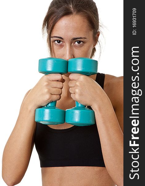 Close-up of a sports Woman working out with dumbbells shallow focus on the dumbbells. Close-up of a sports Woman working out with dumbbells shallow focus on the dumbbells