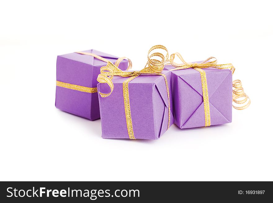 Lilac boxes with golden ribbon isolated on white background. Lilac boxes with golden ribbon isolated on white background