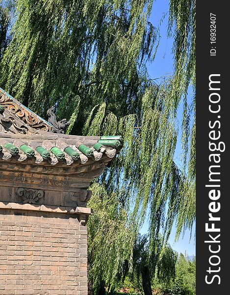 Part of old architecture in Chinese temple, and branch of willow trees, shown as historic building and green environment. Part of old architecture in Chinese temple, and branch of willow trees, shown as historic building and green environment.