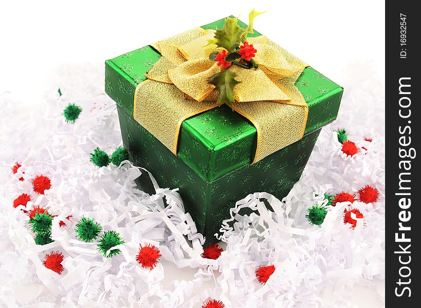 A green wrapped Christmas gift with a wide gold bow and spring of holy. A green wrapped Christmas gift with a wide gold bow and spring of holy.