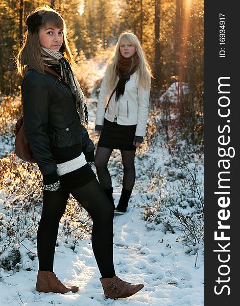 Two young beautiful girls on snow landscape