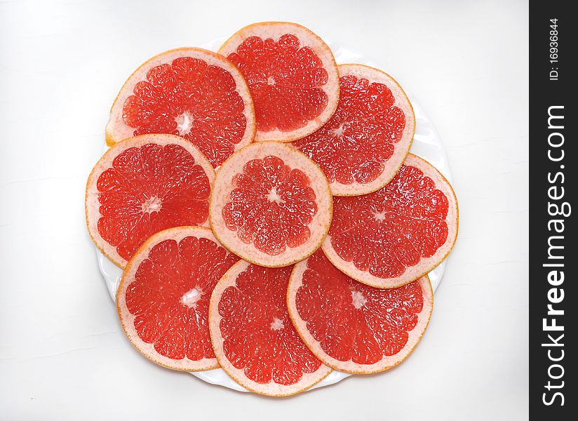 Fresh grapefruit and slices background on a white plate
