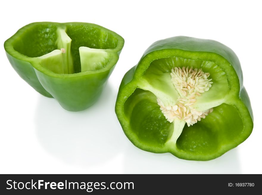 Close up capturing two halves of a green bell pepper arranged over white. Close up capturing two halves of a green bell pepper arranged over white.