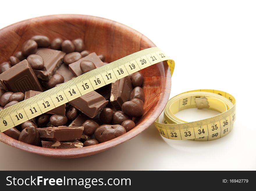 Chocolate in the wood bowl with tape measure. Chocolate in the wood bowl with tape measure