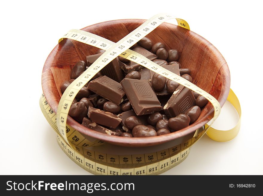 Chocolate in the wood bowl with tape measure. Chocolate in the wood bowl with tape measure
