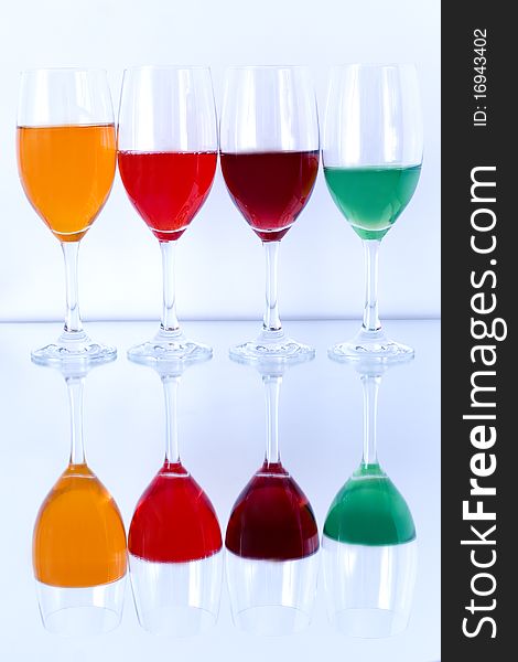 Colored glasses arranged on a glass substrate. Mirror was used as background. Colored glasses arranged on a glass substrate. Mirror was used as background