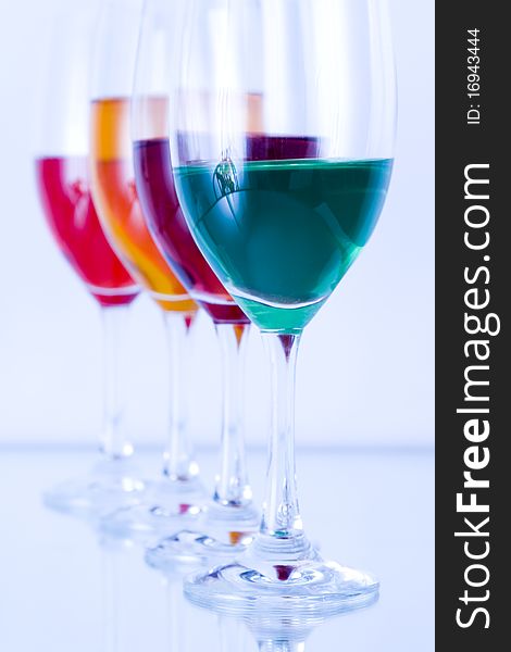 Colored glasses arranged on a glass substrate. Mirror was used as background. Colored glasses arranged on a glass substrate. Mirror was used as background