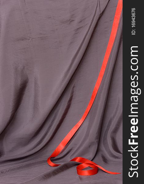 Abstract grey background made from satin with red ribbon. Abstract grey background made from satin with red ribbon