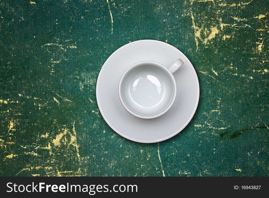 Empty coffee cup on a dirty green table