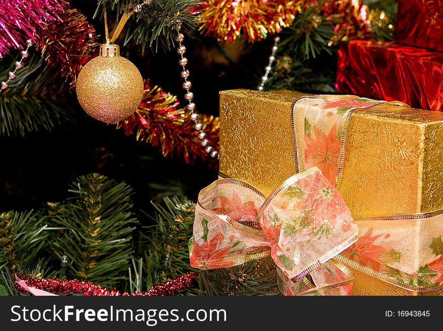 Christmas tree with gold present box, close up