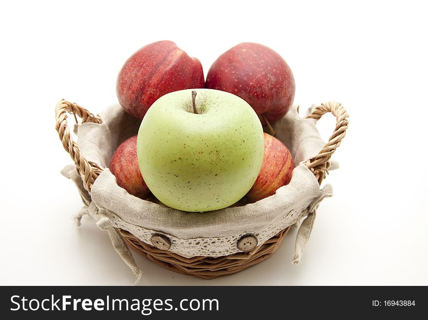 Red apples and green apple in the basket with material