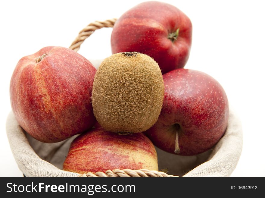 Red apples and kiwi in the basket with material