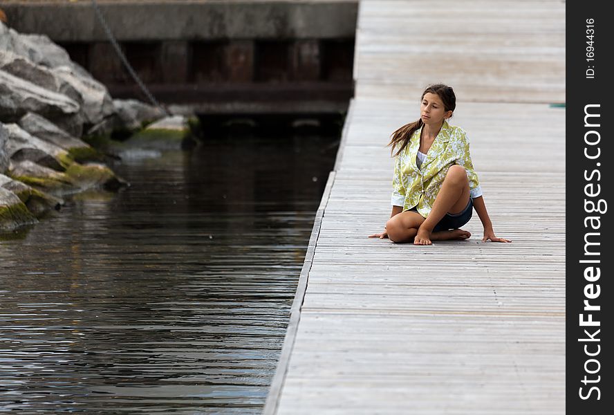 Young girl in Yoga posture on a dock