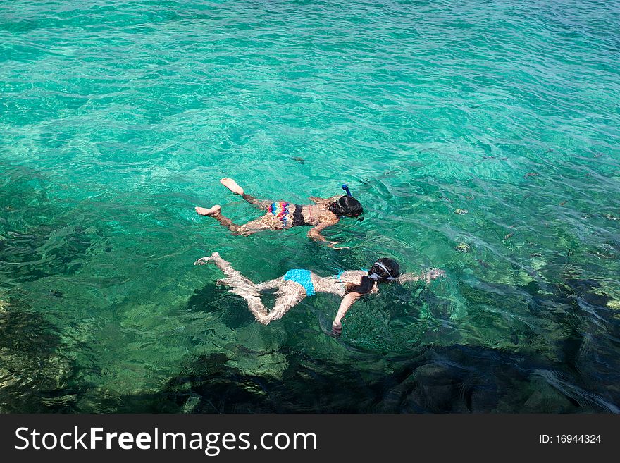 Young girls snorkeling in tropical waters. Young girls snorkeling in tropical waters