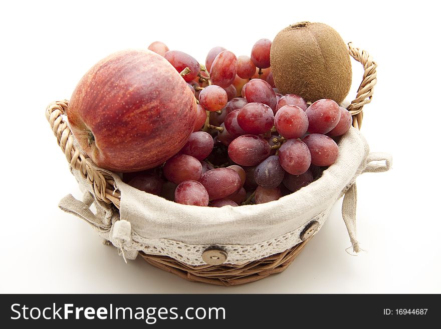 Red grapes with apple and kiwi in the basket